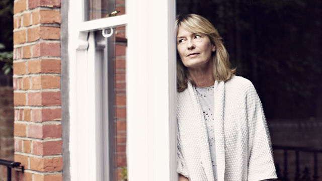 Woman leaning close to an open window door