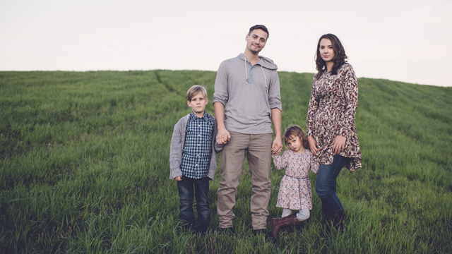 Family with two kids on green field 