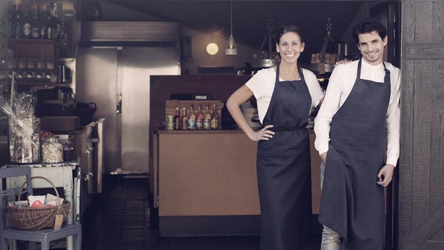 Two waiters welcoming into restaurant