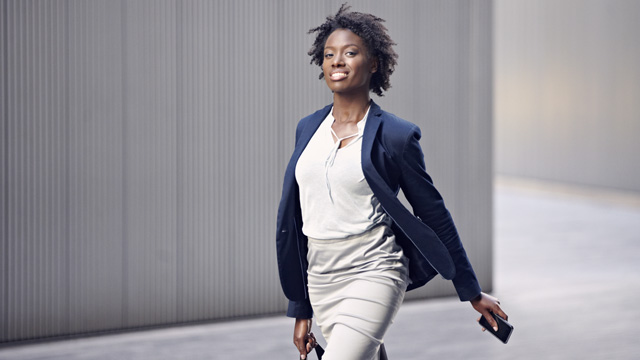 Woman smiling while walking holding a mobile