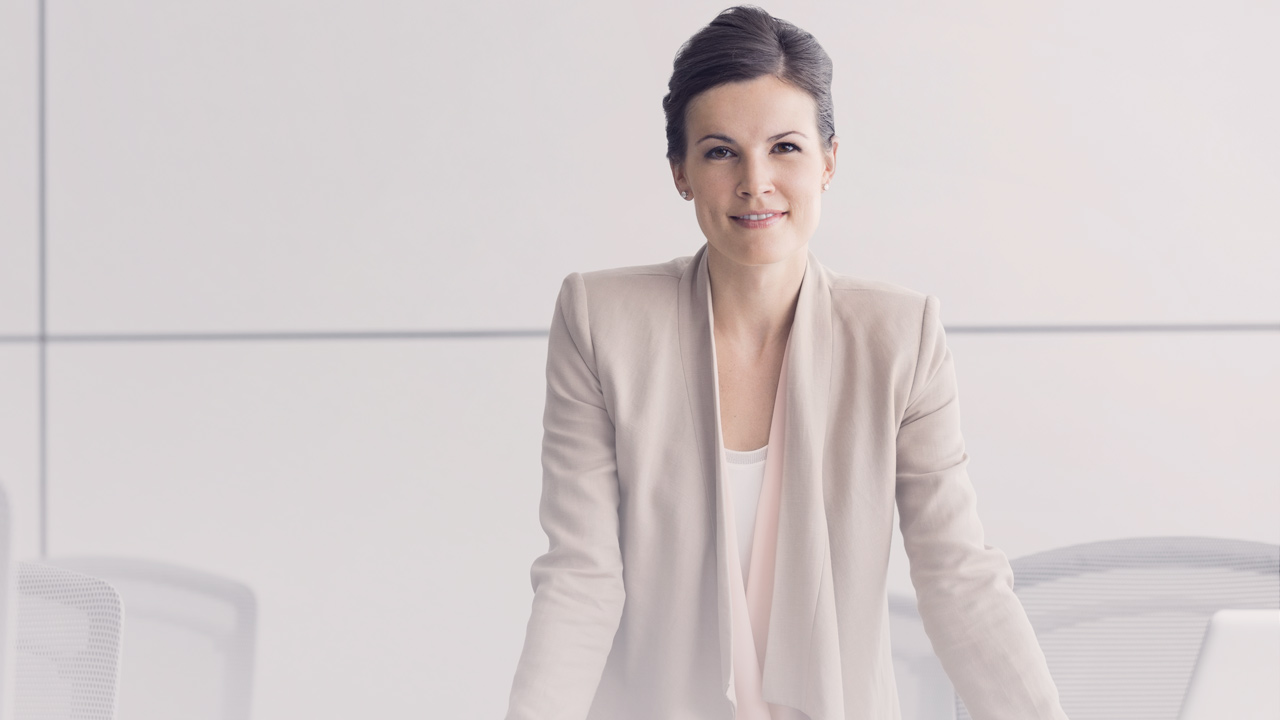 Formal business woman in an office smiling at you