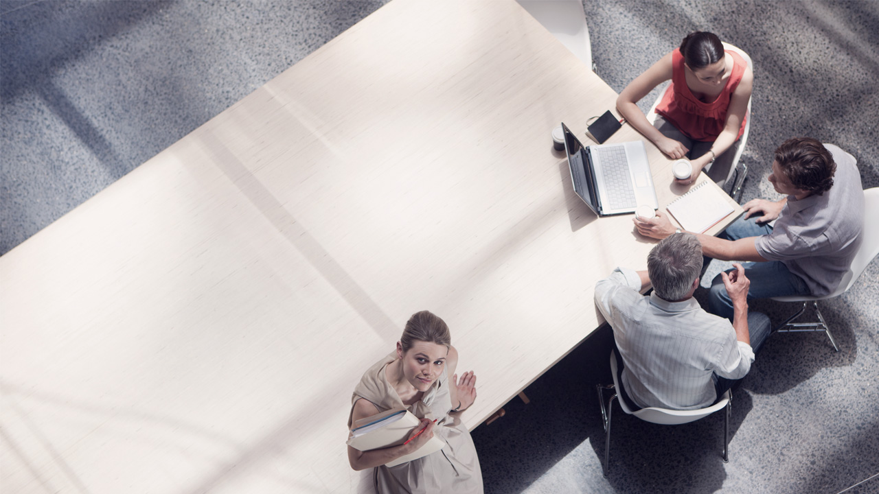 Business meeting with four people talking in an office