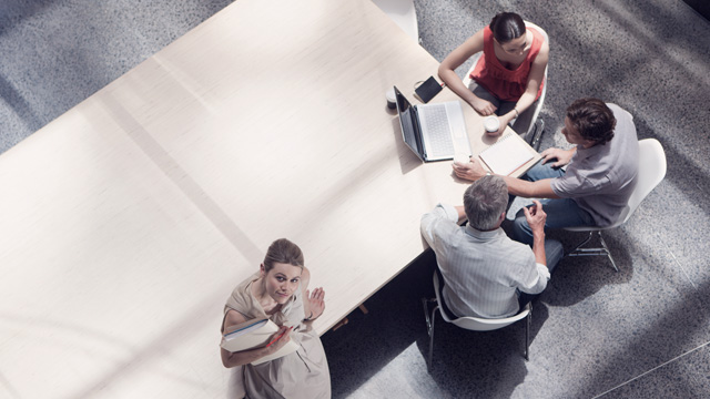 Business meeting with four people talking in an office