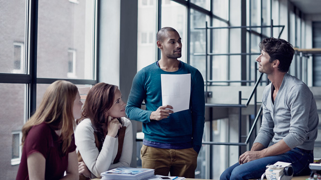 Informal office meeting four people talking - small