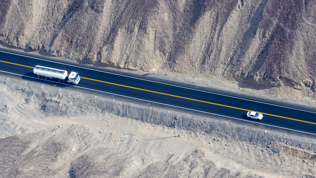 A truck and a small car on the road - small