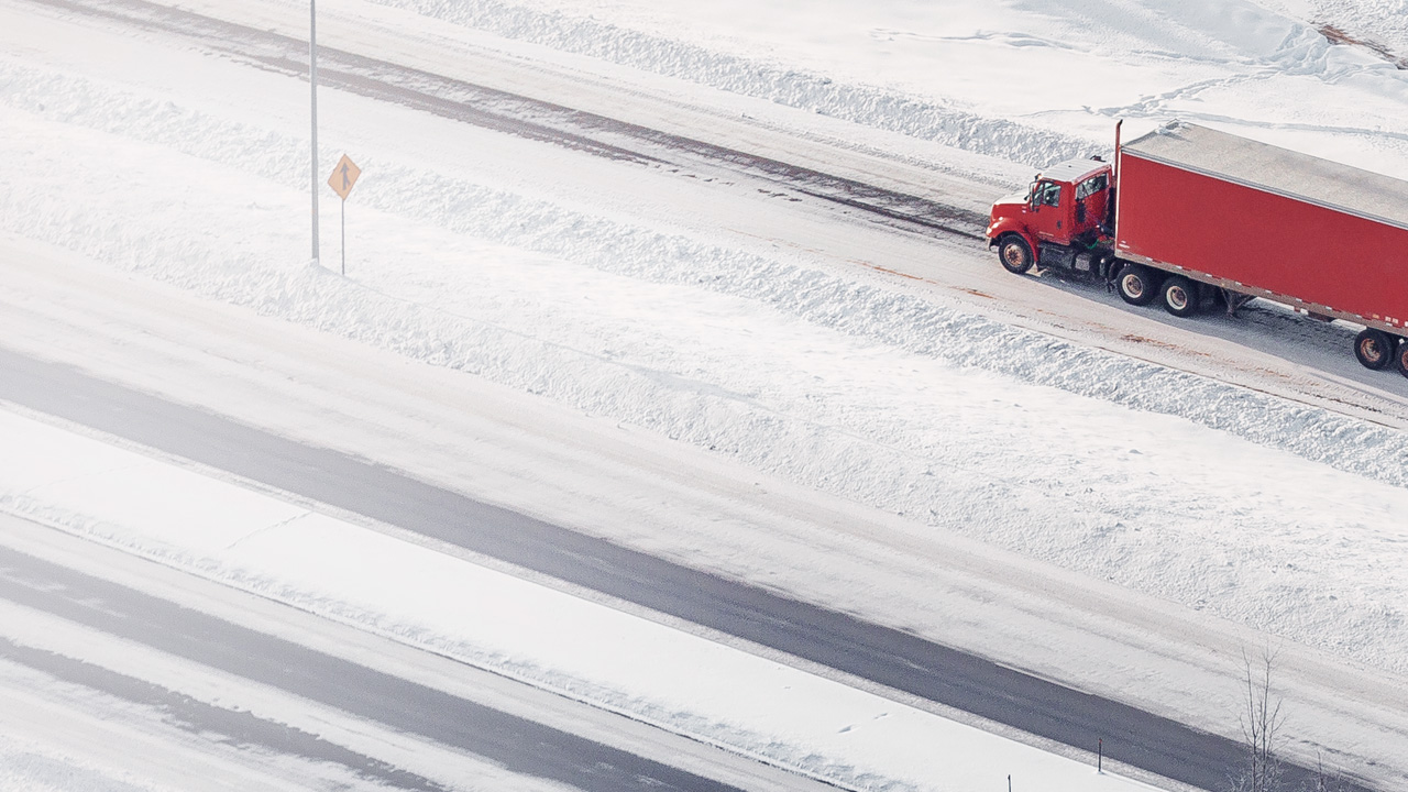 Red truck driving on snowy roads