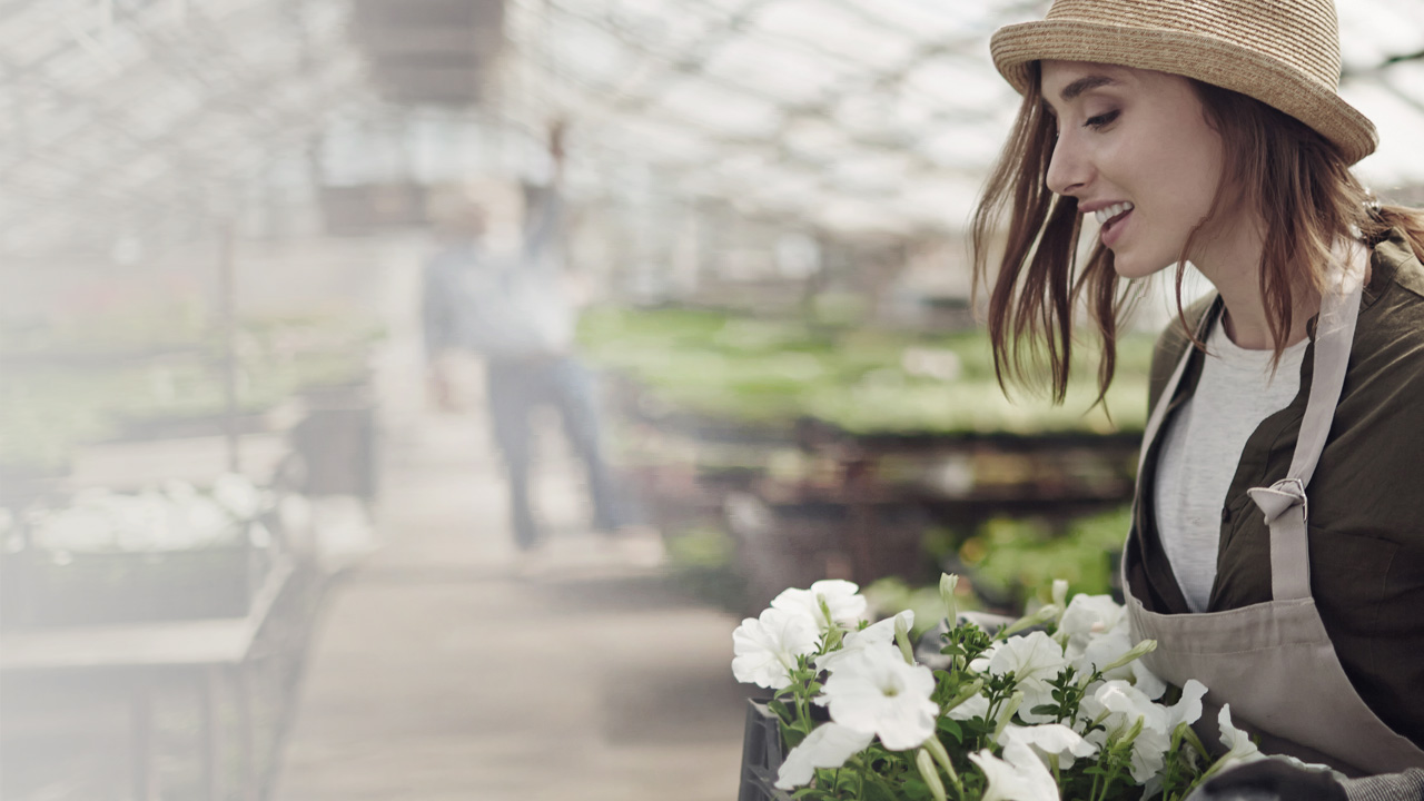 Woman working with flowers in garden store.