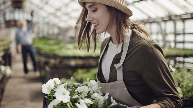 Woman working with flowers in garden store.