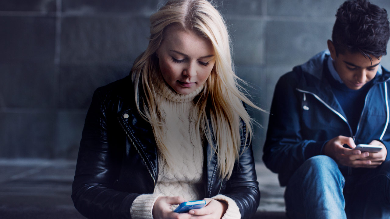 Teenagers looking at their phones and texting