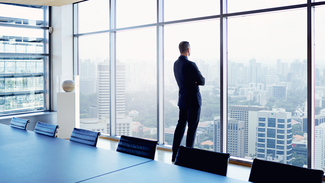 Businessman in meeting room looking out through the window
