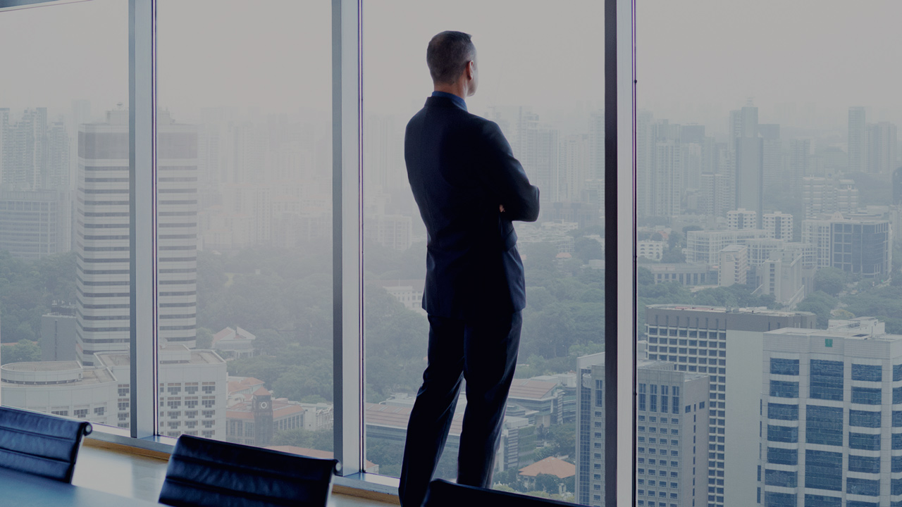 Businessman in meeting room looking out through the window