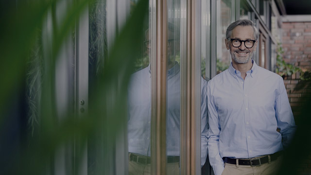 Smiling man leaning against window