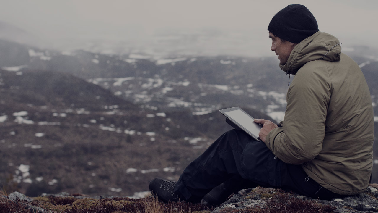 Mann i naturen med tablet