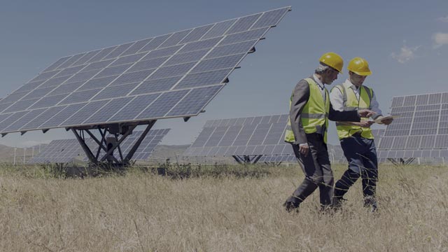 construction workers in solar panel field small overlay
