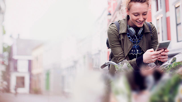 girl on bike looking at her mobile phone