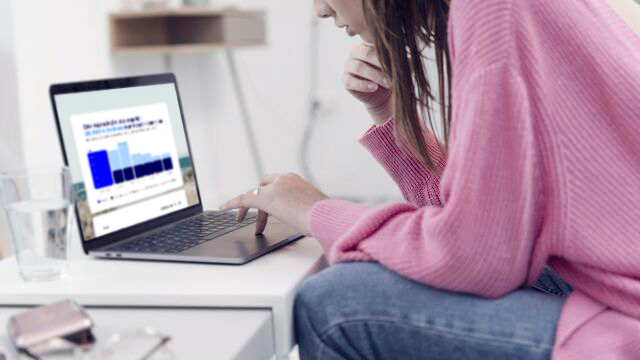 Ung kvinna som sitter framför en dator