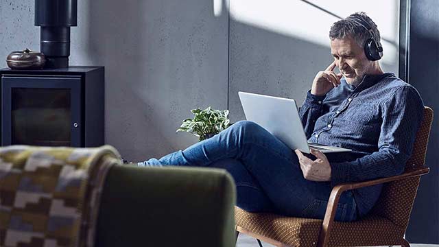 Mature man listening to music on laptop