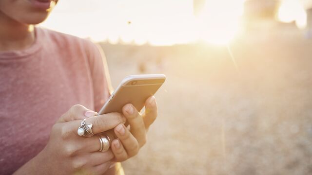 woman_using_smartphone_at_sunset_small