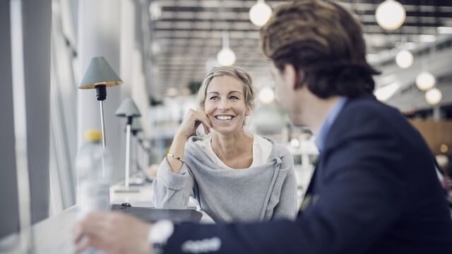 happy-businesswoman-talking-to-colleague-at-cafe-small